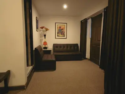 a living room with a couch and a chair at Hotel Montecristo Cusco in Cusco