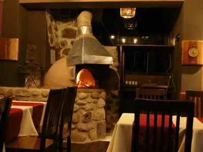 a stone oven in a restaurant with a table and chairs at Hotel Montecristo Cusco in Cusco