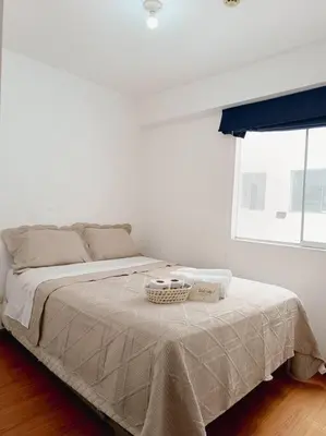 a white bedroom with a bed with a basket on it at Apartamento moderno y céntrico en Lima, 3 Dormitorios in Lima