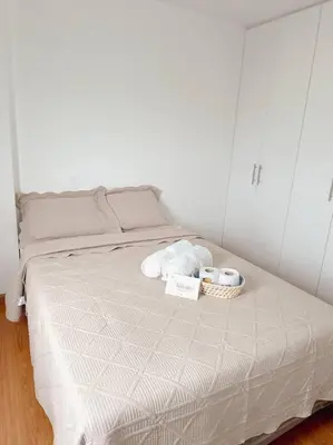 a white bed with two towels and two cups on it at Apartamento moderno y céntrico en Lima, 3 Dormitorios in Lima
