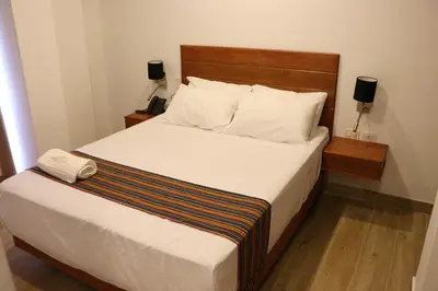 a bedroom with a large bed with white sheets and pillows at Ribera del Rio Club Resort in Cieneguilla