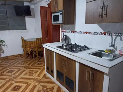 a kitchen with a sink and a stove top oven at Hostal Cielo Azul in Canta