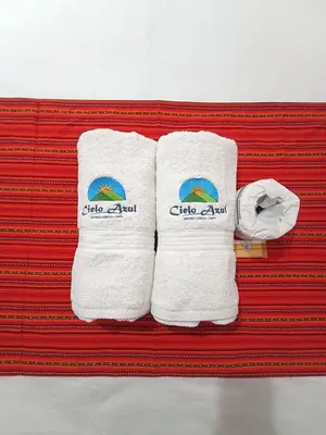 two white towels with the clio aid written on them at Hostal Cielo Azul in Canta