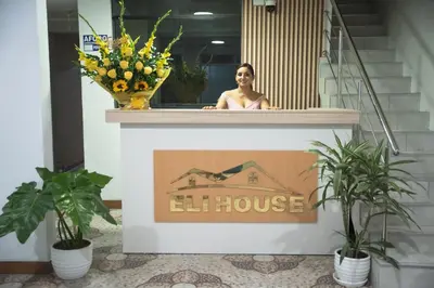 a woman standing on the ledge of a lift house sign at Hotel Eli House in Nazca