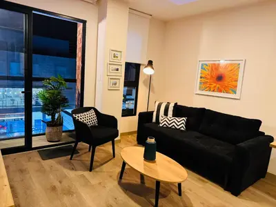 a living room with a black couch and a table at MONTERRICO POLO APARTS #17 - Dpto de estreno con Balcón Frente Embajada USA in Lima