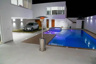 a swimming pool in the middle of a house with a car at CA3 - Casa de Lujo, Fiesta y Piscina - Punta hermosa in Punta Hermosa