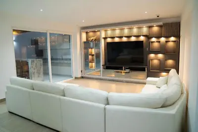 a living room with a white couch and a television at CA3 - Casa de Lujo, Fiesta y Piscina - Punta hermosa in Punta Hermosa
