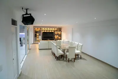 a dining room and living room with a table and chairs at CA3 - Casa de Lujo, Fiesta y Piscina - Punta hermosa in Punta Hermosa