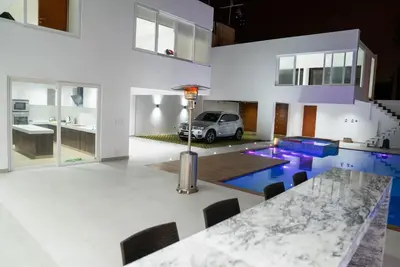 a kitchen with a table and a car in a house at CA3 - Casa de Lujo, Fiesta y Piscina - Punta hermosa in Punta Hermosa
