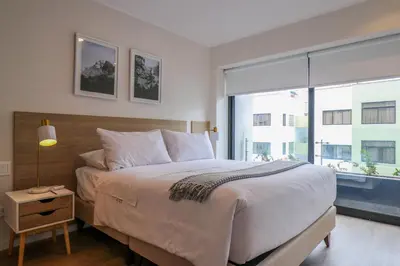 a bedroom with a large bed and a large window at Liven in Miraflores by Wynwood House in Lima