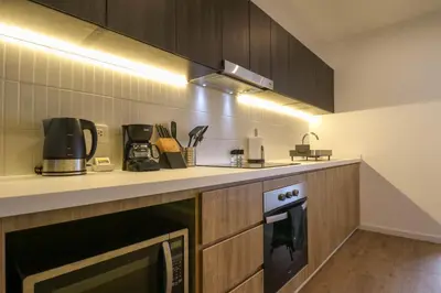 a kitchen with a stove and a microwave at Liven in Miraflores by Wynwood House in Lima