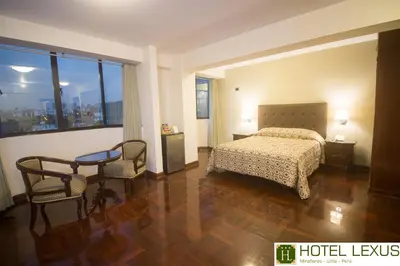 a hotel room with a bed and a table and chairs at Hotel Lexus in Lima