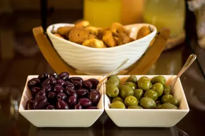 two bowls of fruit on a table with a basket of bread at Hotel Lexus in Lima