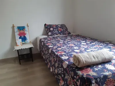 a small bedroom with a bed and a mirror at Lily House in Ica