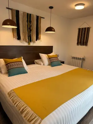 a bedroom with a large bed with a yellow blanket at CASA CRISTOBAL Centenario in Cusco