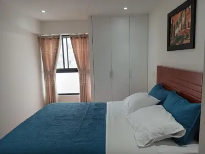 a bedroom with a bed with blue sheets and pillows at Departamento Pardo Miraflores in Lima