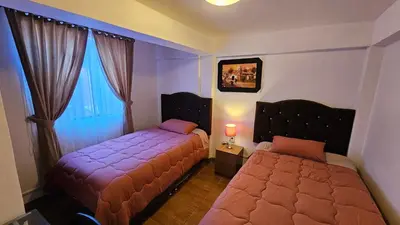 a bedroom with two beds and a window at Casa Independiente muy cerca al centro historico - Los Profesionales in Cusco