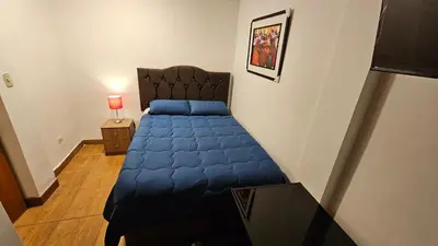 a bedroom with a bed with a blue blanket at Casa Independiente muy cerca al centro historico - Los Profesionales in Cusco