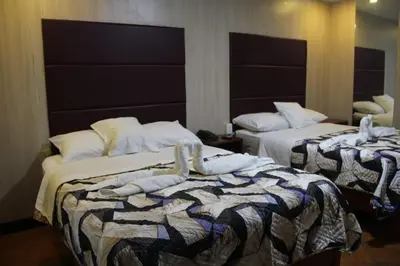 two beds in a hotel room with towels on them at 100pre feliz in Lima