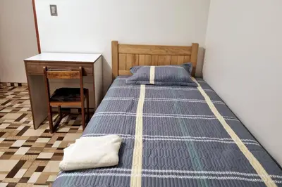 a bed in a room with a desk and a bed sidx sidx sidx at Apartamento amplio y acogedor in Huancayo