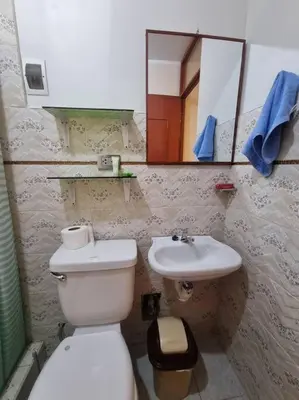 a bathroom with a white toilet and a sink at Apartamento amplio y acogedor in Huancayo