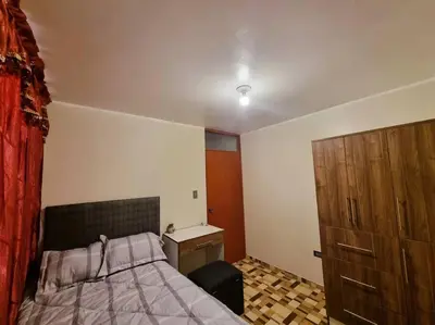 a bedroom with a bed and a wooden dresser at Apartamento amplio y acogedor in Huancayo
