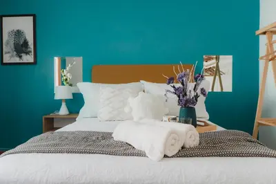 a bedroom with a bed with towels and a blue wall at Casa Bellido - Miraflores Private Rooms - Cocina Compartida - Wifi in Lima
