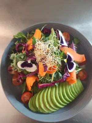 a salad in a bowl with vegetables and pickles at Sequeiros Garden in Ollantaytambo