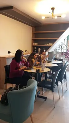 a group of people sitting at tables in a restaurant at Mandala Lux Hotel in Pisco
