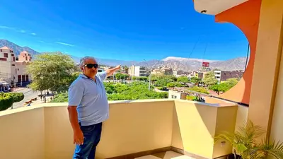 a man standing on a balcony with a view of a city at Hospedaje Sol de Oro in Nazca