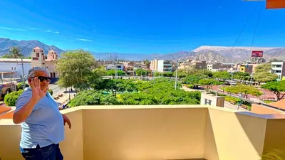 a woman talking on a cell phone in a city at Hospedaje Sol de Oro in Nazca