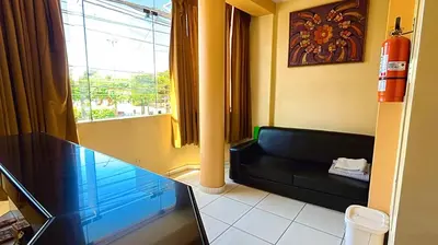 a living room with a black couch and a window at Hospedaje Sol de Oro in Nazca