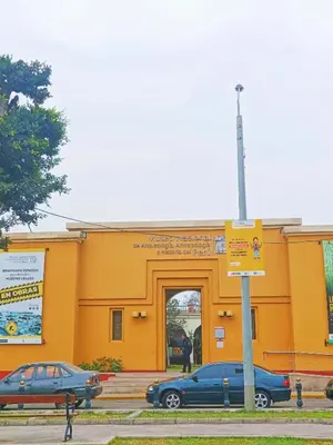 two cars parked in front of a yellow building at Casona Turística Gonzales in Lima