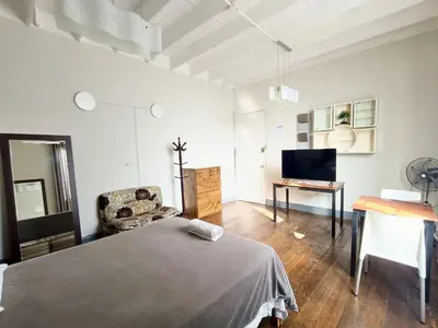 a living room with a bed and a television at Casona Turística Gonzales in Lima