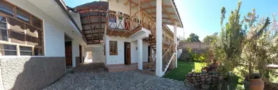 a white building with a balcony on the side of it at Hostal Miramonti in Urubamba