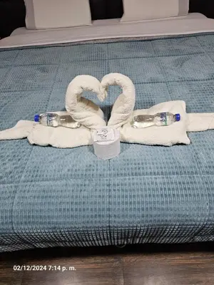 two towels and two water bottles on a bed at Hospedaje Paqcha in Cusco