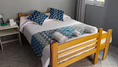 a bed with blue and white pillows on it at Les Sorciers ooo in Cusco
