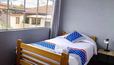 a small bed in a room with a window at Les Sorciers ooo in Cusco