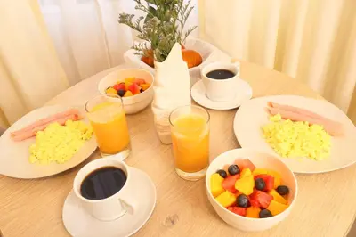 a wooden table with plates of food and drinks at Rig Vêda Hotel in Lima