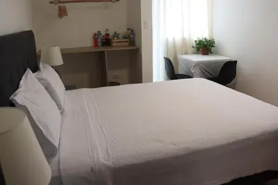 a bedroom with a white bed and a table and a window at Casablanca Lima in Lima