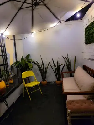 a room with a yellow chair and some plants at Tripper Monkey House Miraflores in Lima