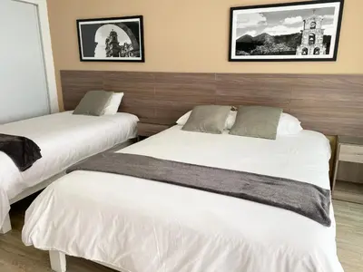 two beds in a hotel room with white sheets at Enjoy Lima in a Renovated and Private Apt D in Lima