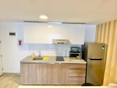 a kitchen with white cabinets and a stainless steel refrigerator at Enjoy Lima in a Renovated and Private Apt D in Lima