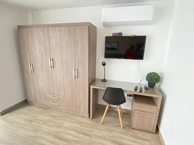 a bedroom with a desk and a cabinet and a chair at Enjoy Lima in a Renovated and Private Apt D in Lima