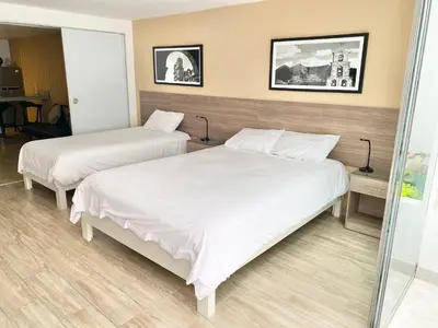 two beds in a hotel room with white sheets at Enjoy Lima in a Renovated and Private Apt D in Lima