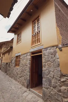 an old stone house with a door and windows at Casa Alba Ollantaytambo in Ollantaytambo