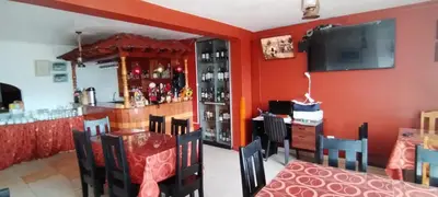 a dining room with red walls and a bar at IntiKilla in Mollepata