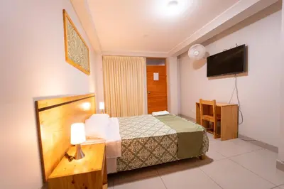 a hotel room with a bed and a flat screen tv at Hostal Los Balcones II in Nazca