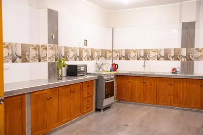 a kitchen with wooden cabinets and stainless steel appliances at Hostal Los Balcones II in Nazca