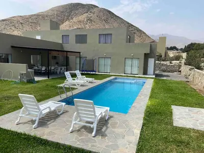 a house with a swimming pool with chairs and a house at Casa de Campo en Cieneguilla in Hacienda Cienguilla